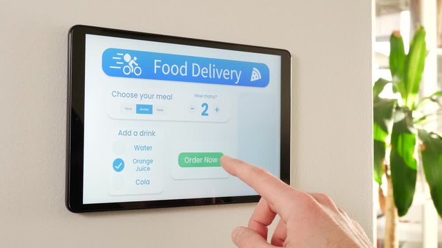 Smart house with a food delivery system on a wall-mounted display screen. The technology used in a smart home.