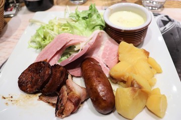 Assiette de saucisse de Montbéliard et charcuterie avec fromage concoyotte et salade verte - ville de Montbéliard - Département du Doubs - Région Franche Comté - France