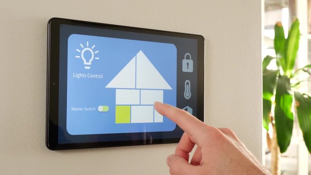 Switching the lights of a smart house on a display mounted on a wall. Digital screen controlling the home.