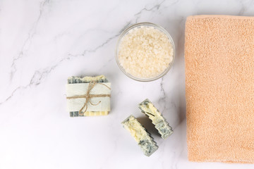 Soap, salt and a towel on a marble surface. Body care.
