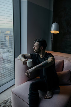 man sitting on sofa looking at the window