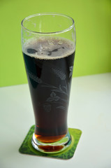 glass of beer on green background