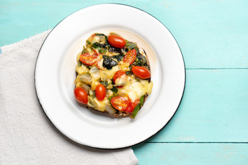 Portobello stuffed with spinach and cheese on turquoise background