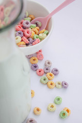 Jug of milk next to unfocused fruit cereal
