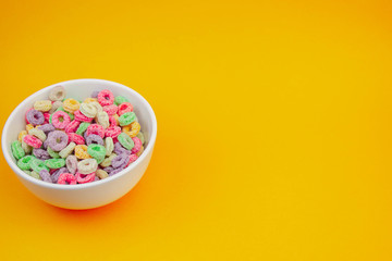 Fruit cereal in white cup in a corner on orange texture