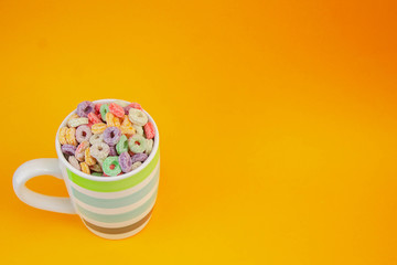 Fruit cereal in coffee cup on orange texture
