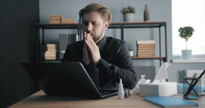 Handsome middle-aged businessman suffering flu working in office, epidemics