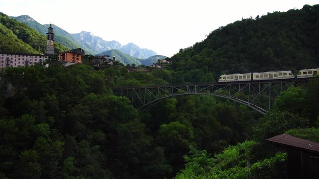 Scenic swiss train Centovalli Railway Locarno-Domodossola on bridge. Intragna village. Swiss Alps. Ticino Switzerland in summer, 4k. 