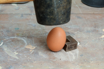 Egg being smashed or cracked with a hammer
