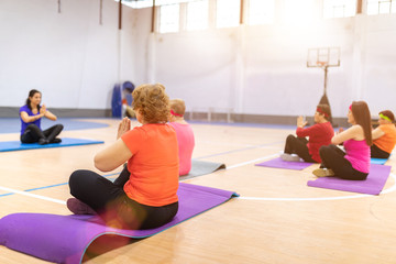 older women doing gymnastics and yoga in the ward with coach