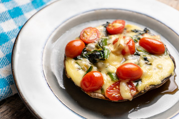 Portobello stuffed with spinach and cheese on wooden background