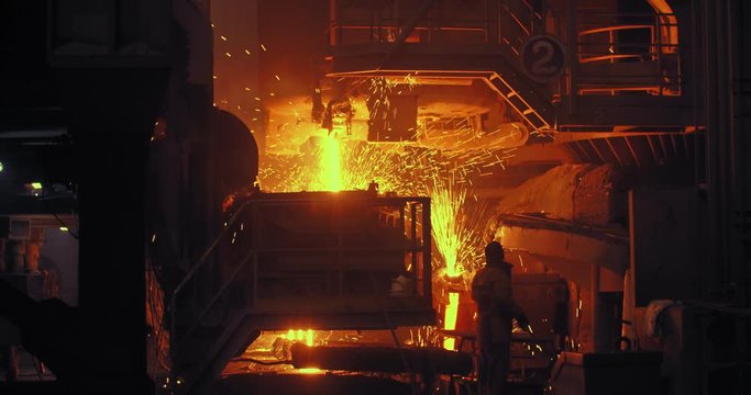 Hard work in a foundry. Metal smelting furnace in steel mill. Molten metal pouring, metallurgy, steel casting foundry. Steel manufacturing