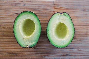 healthy ingredients, avocado cut in halves on cutting board