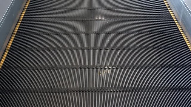 Moving walkway, moving sidewalk, moving pavement, travelator, horizontal escalator, moveator, or auto walk at an international airport terminal, in modern office centre