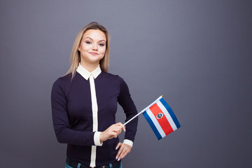 Immigration and the study of foreign languages, concept. A young smiling woman with a costa rica flag in her hand.