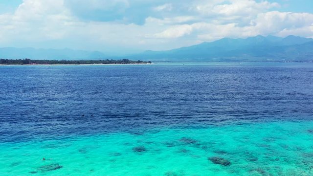 beautiful turquoise colors of the water on the cloudy day, Philipines. Mountains and small tropical island in the distance