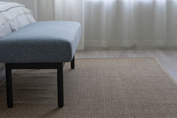 Carpet and blue bench near king size bed by the window.