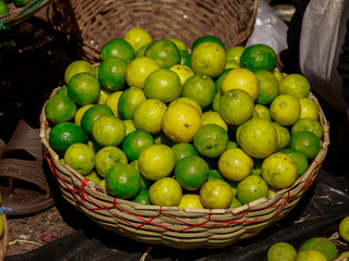 Green yellow lemon kept in basket in vegetable market i