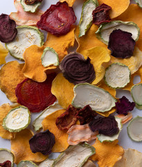 Crisp crunchy organic vegetable chips oven-baked pumpkin, beetroot, squash, tomato, carrot chips snacks on a white background