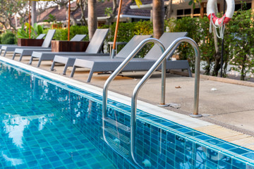 Ladder stainless handrails for descent into swimming pool. Swimming pool with handrail . Ladder of...