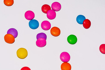 Chocolate coated candies on white background