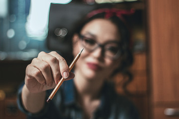 Beautiful asian girl holding a pencil