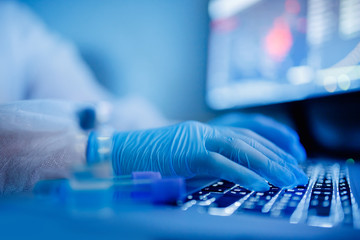 Medical research scientist work online computer blood test on slide in modern laboratory. Blue...