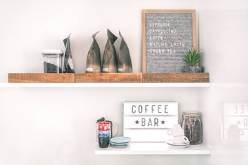 Coffee shop menu sign on wall shelves hipster trendy store for espresso shots. Felt letter board lightbox showing text selling cappuccino, latte, matcha tea.