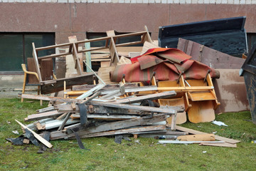 Odl carpets and broken  chairs and furniture at the garbage dump near the  apartment  building - obrazy, fototapety, plakaty