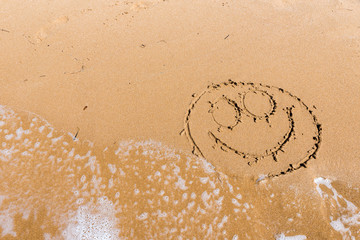 Smile draw on the shore of the sea