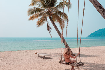 girl swinging on a swing by the sea