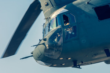 Military combat and war with Chinook helicopter close up flying through the chaos. Military concept...
