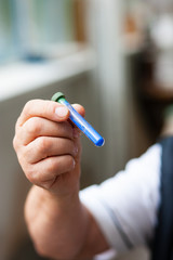 Eine männliche Person hält ein Röhrchen mit Lapislazuli Pigment