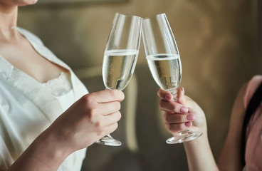 Cheers! Photo bride with her friends drinking champagne from glasses