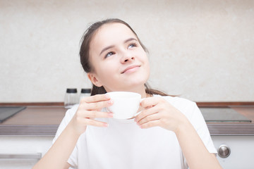 Beautiful european girl drinks aromatic coffee for breakfast
