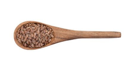 Linseeds or flax seed on a brown wooden spoon seen directly from above and isolated on white background
