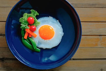 A poached egg served with steamed peas, carrots, cherry tomatoes