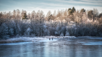 Obraz na płótnie Canvas Beautiful winter day with ice fishing. Panorama of a winter landscape with a frozen lake and white trees in the frost