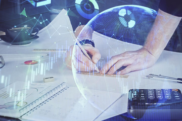 Double exposure of man writing on paper with forex graph.