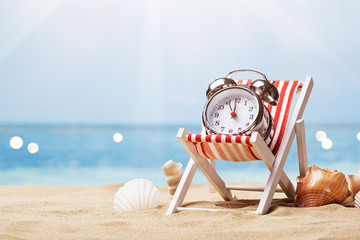 Alarm Clock On Deck Chair On Beach