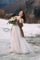 Fototapeta na wymiar Lovely young stylish bride on a background of a winter forest.