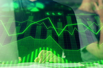 Forex graph with businessman typing on computer in office on background. Concept of analysis....