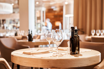Wine glasses in the foreground. The chairs and table for guests, served with cutlery and crockery