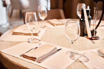 Wine glasses in the foreground. The chairs and table for guests, served with cutlery and crockery