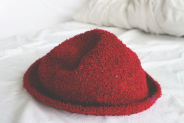A red hat resting on the bed