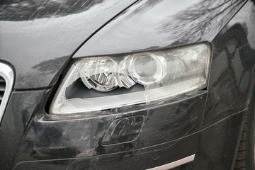 Small black car with damaged headlamp after collision © Oleg