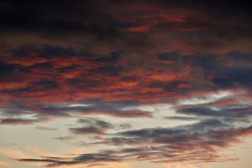 beautiful dramatic sky with dark and bright clouds at sunset, summer landscape, golden sunlight