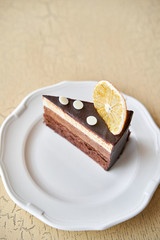 Chocolate sponge cake, with mousse, decorated with Orange slice and meringue. Breakfast in the cafe, morning coffee. on wooden table.