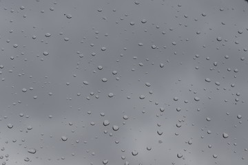 Water drops on window background on cloudy day.