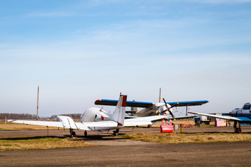 A small plane stands in the parking lot of an old airfield. Wings. Airport. Airfield. Flights by plane.